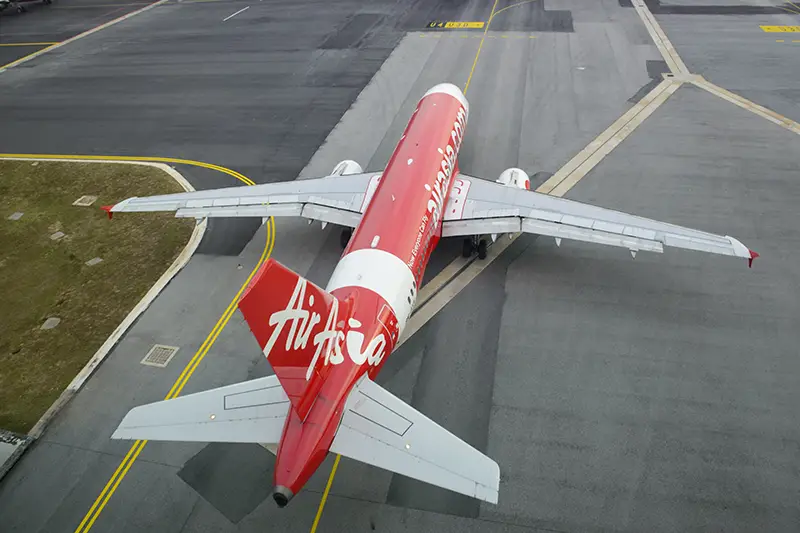 AirAsia plane preparing for takeoff, symbolizing budget-friendly flight options for traveling to Malaysia.