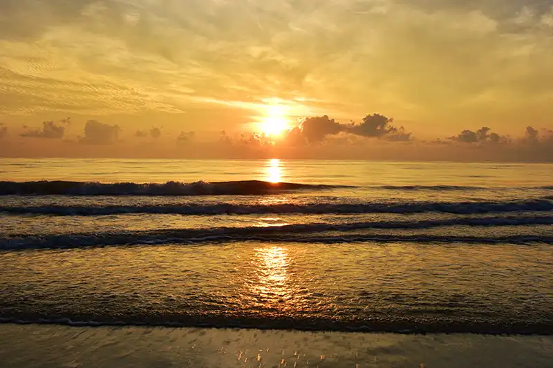 Golden sunset over the calm waves at Cherating Beach, a serene destination for short trips in Malaysia
