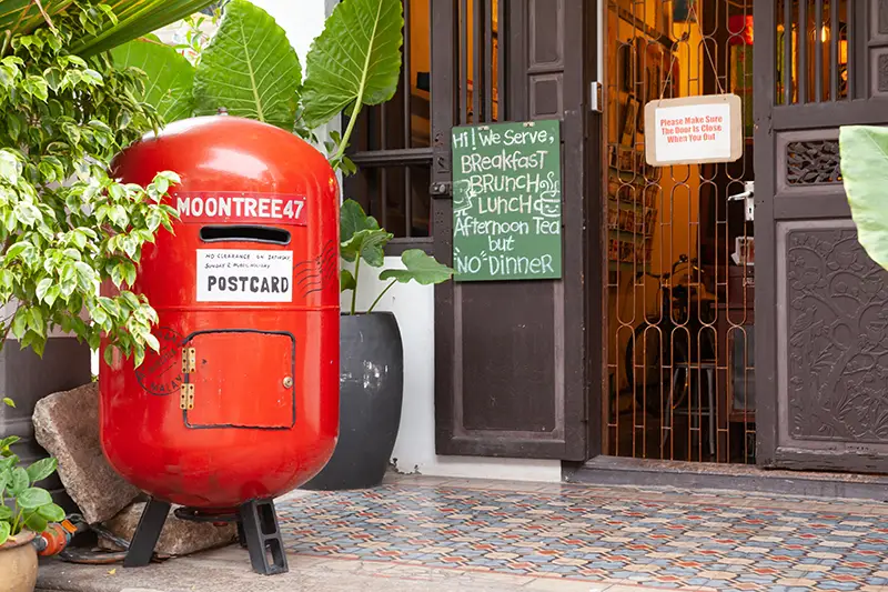Guesthouse in Penang with a red vintage mailbox and open entrance, offering affordable accommodation for budget travelers in Malaysia.