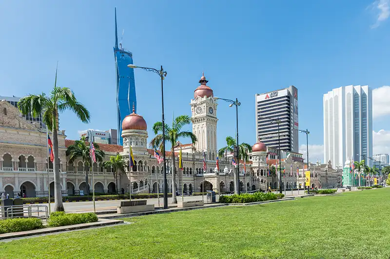 Merdeka Square in Kuala Lumpur with iconic Sultan Abdul Samad Building and modern skyscrapers in the background. One of the most popular to visit during excursions in Kuala Lumpur.