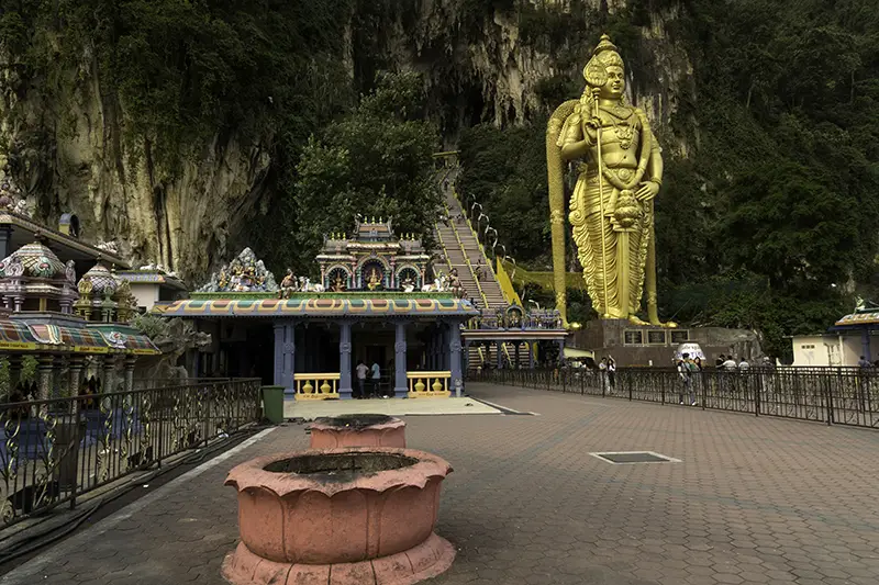 View of Batu Caves in 2015 featuring the golden Lord Murugan statue, temple structures, and staircase before the 2018 renovations.
