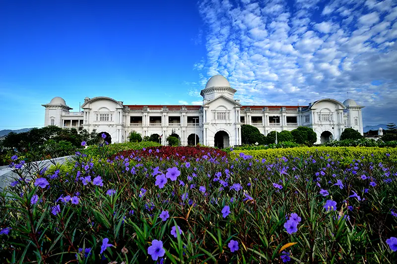The beautiful Ipoh Railway Station, also known as the 'Taj Mahal of Ipoh,' is a must-visit historical landmark surrounded by colorful gardens.
