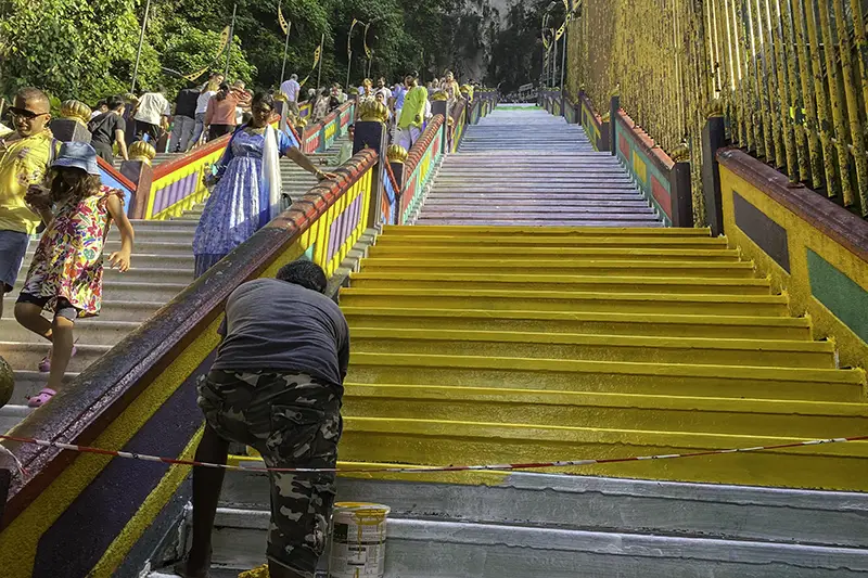 Worker repainting the rainbow steps at Batu Caves in December 2024 as part of preparations for the Thaipusam celebration