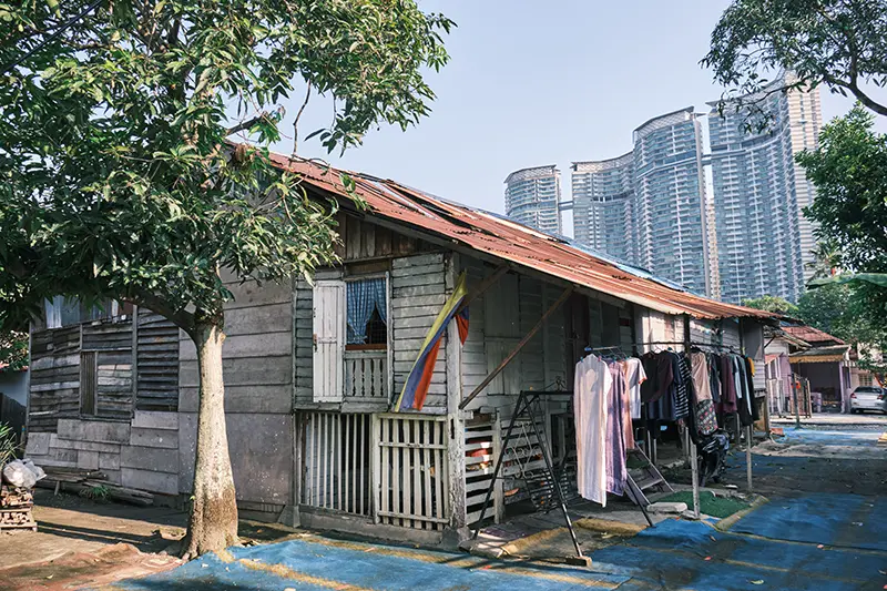 Traditional Malay house in Kampung Baru, Kuala Lumpur, with modern skyscrapers in the background. One of the highlight during Kuala Lumpur city tour