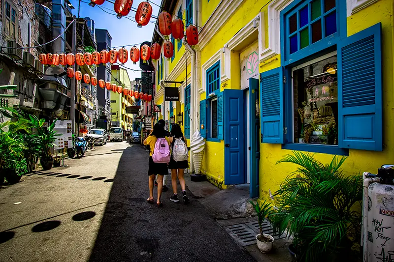 Kwai Chai Hong Alley in Kuala Lumpur Chinatown, featuring colorful restored buildings, red lanterns, and street art.