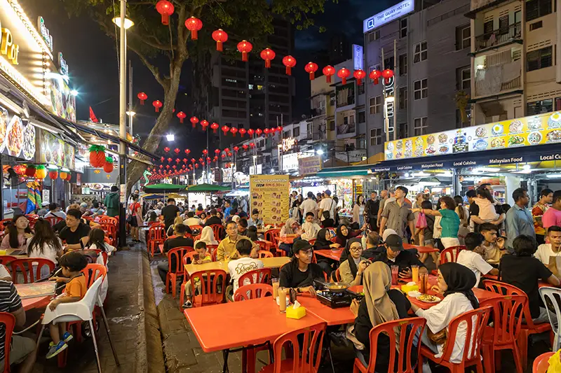 Crowds dining at Jalan Alor night street food market in Kuala Lumpur, known for its lively atmosphere and variety of local dishes