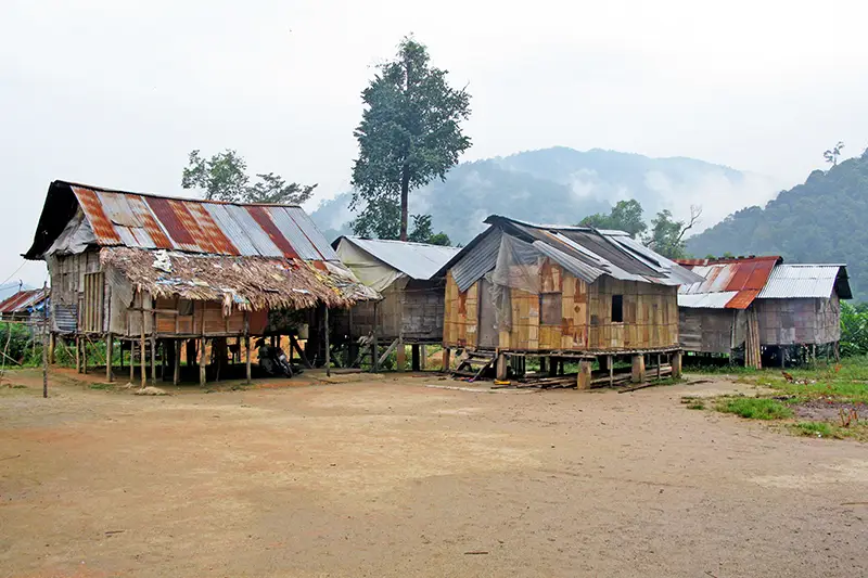Traditional wooden houses in an Orang Asli village surrounded by hills in Cameron Highlands, featured in a Cameron Highlands travel guide